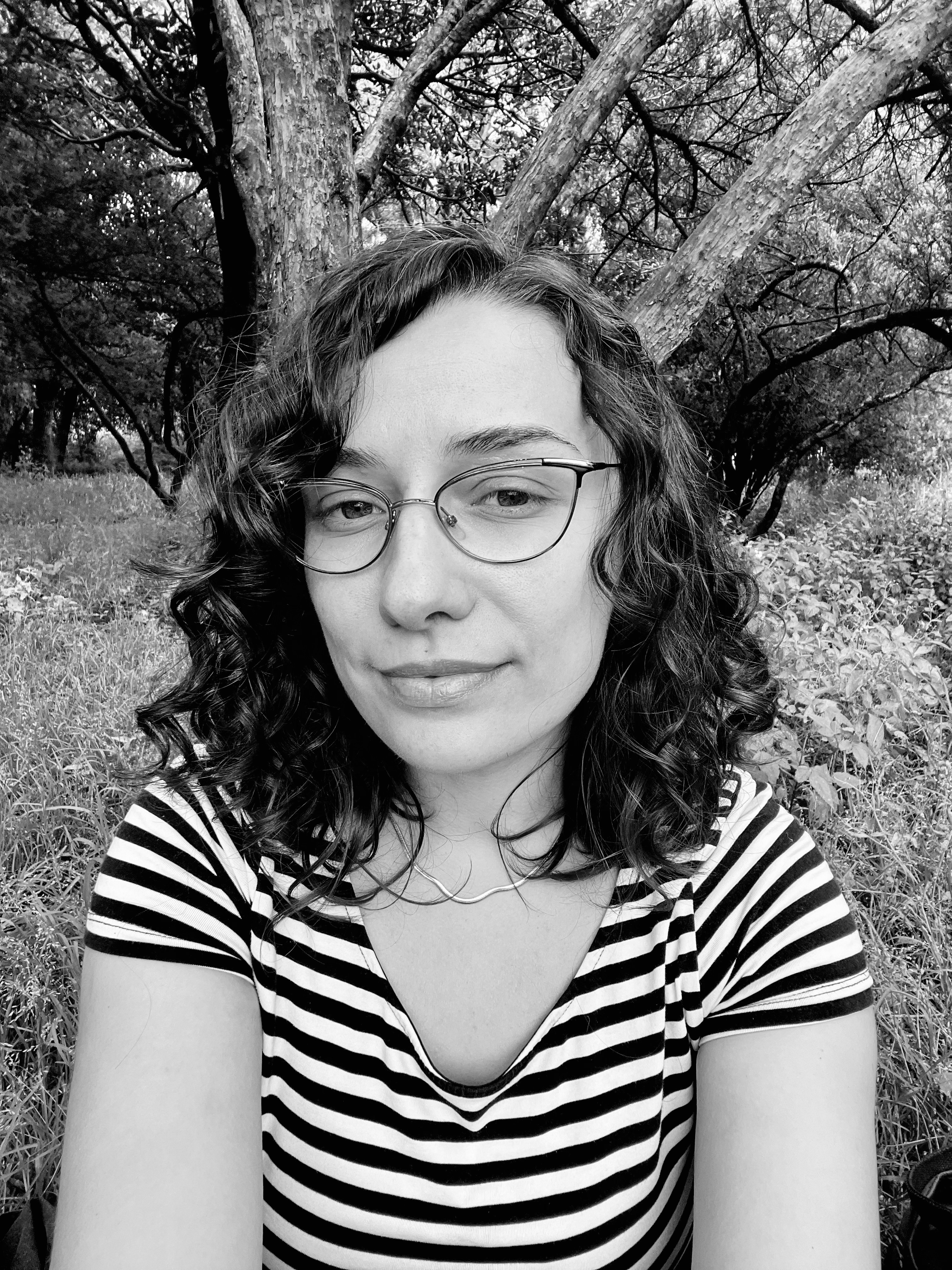 Portrait of a woman with brown hair on a flat gray background.